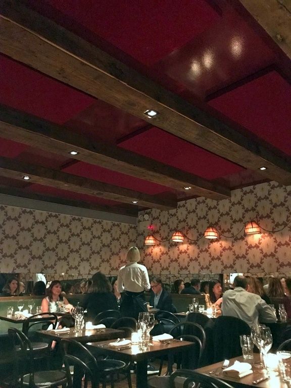 Salle de restaurant animée avec plafond à poutres et éclairage intégré